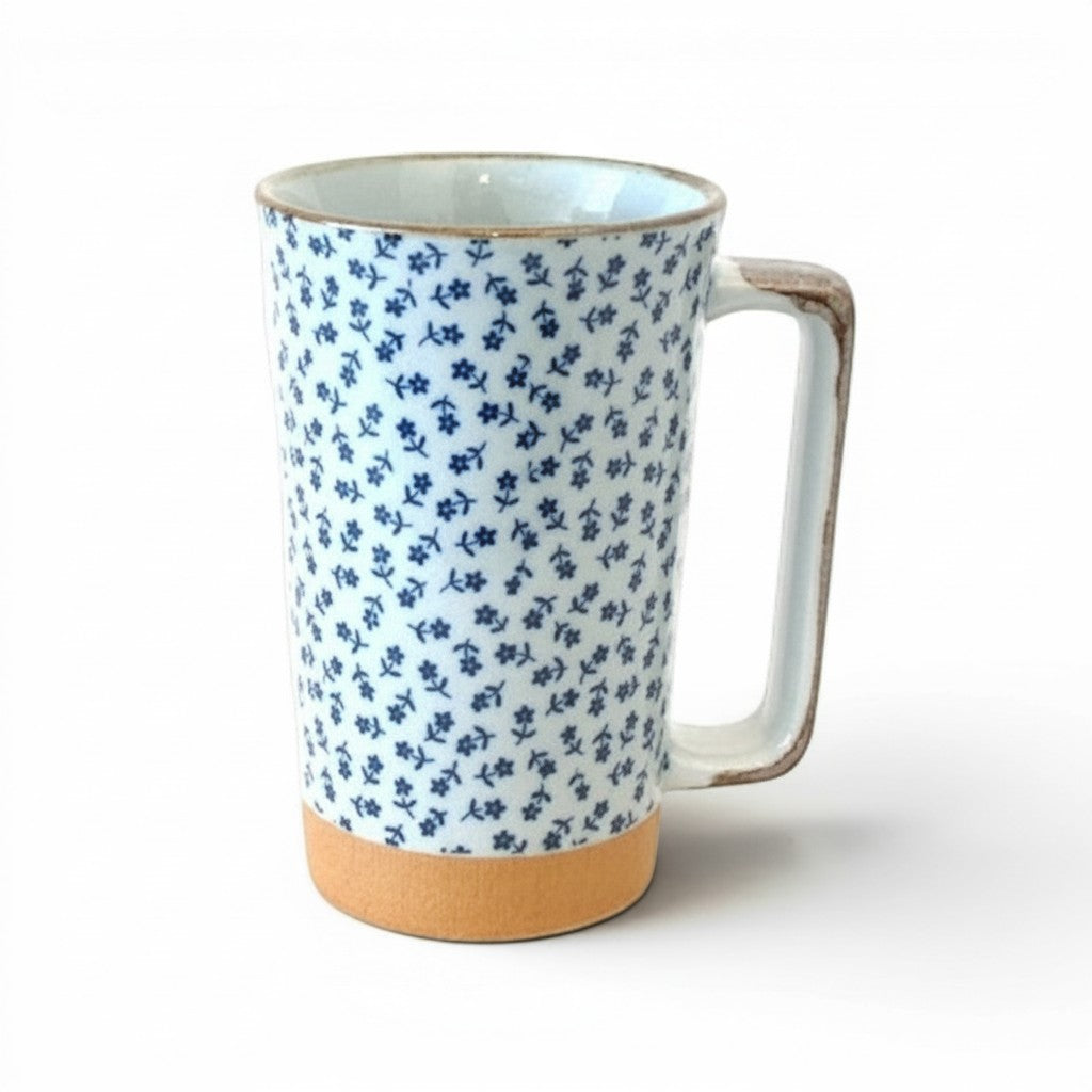 Grand mug Yugen lab en céramique blanche et bleue avec motif floral délicat, anse rectangulaire et base terre cuite.
