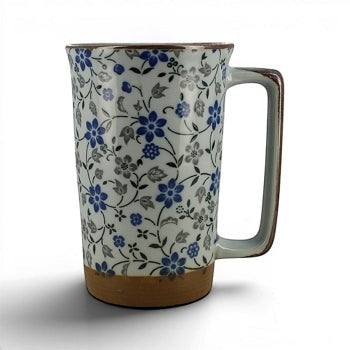Mug en céramique Yugen lab L'Amarelis avec motifs floraux bleus et gris, anse rectangulaire et base en terre naturelle.