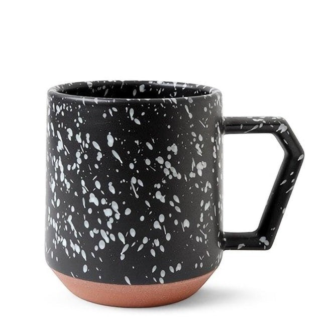 Mug Yugen lab en céramique noire avec motif éclaboussures blanches et base en terre cuite naturelle