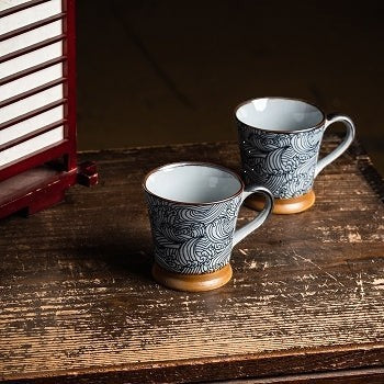 Deux mugs Yugen lab en céramique avec motif vagues Seigaiha bleu et blanc sur une table en bois rustique