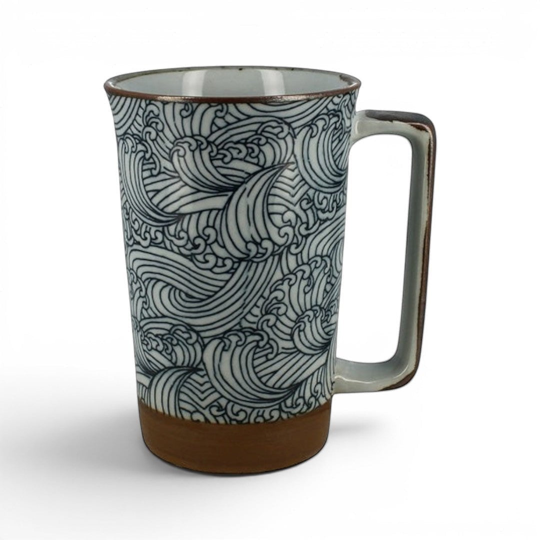 Mug en céramique Yugen lab avec motif de vagues japonaises bleu et blanc et base brune, anse rectangulaire.
