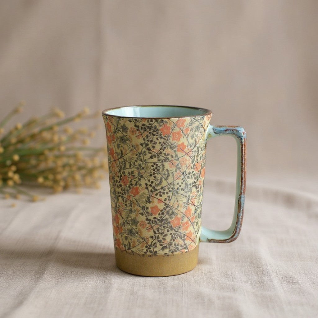Mug en grès Yugen lab avec motifs floraux rouges et noirs sur fond texturé et anse ergonomique