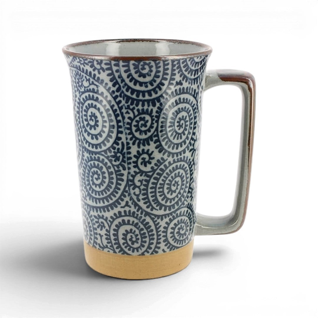 Mug japonais Yugen lab en grès bleu avec motif takokarakusa, anse bronze et socle beige naturel.