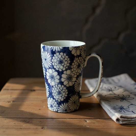 Grand mug Yugen lab en céramique bleu et blanc avec motif floral japonais posé sur une table en bois