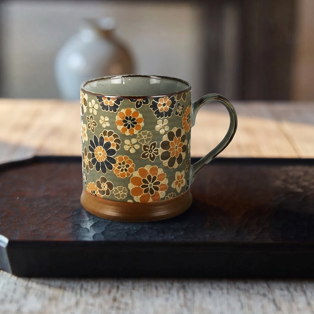 Mug japonais Yugen lab Oogimai en céramique émaillée à motifs floraux ocre, bleu et vert grisé sur plateau sombre