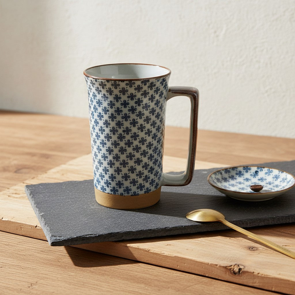 Grand mug japonais Yugen lab bleu et blanc à motifs trèfles avec anse, posé sur une ardoise avec une cuillère dorée.