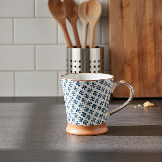 Mug japonais Yugen lab en céramique blanche avec motifs trèfles bleus et base en terre cuite sur un plan de travail