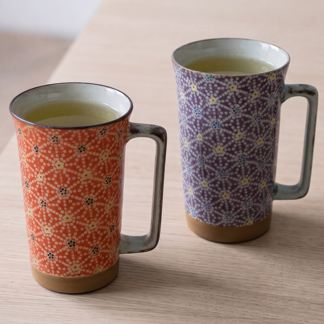 Deux mugs Yugen lab en céramique émaillée mate avec motif floral hanashibori, coloris rouge orangé et violet profond.
