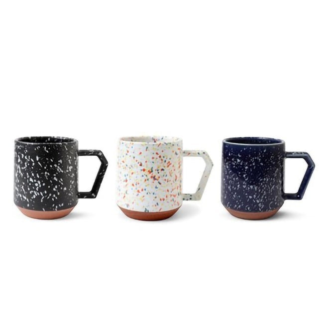 Trois mugs Yugen lab en céramique avec motifs mouchetés, anses géométriques et base en terre cuite apparente.