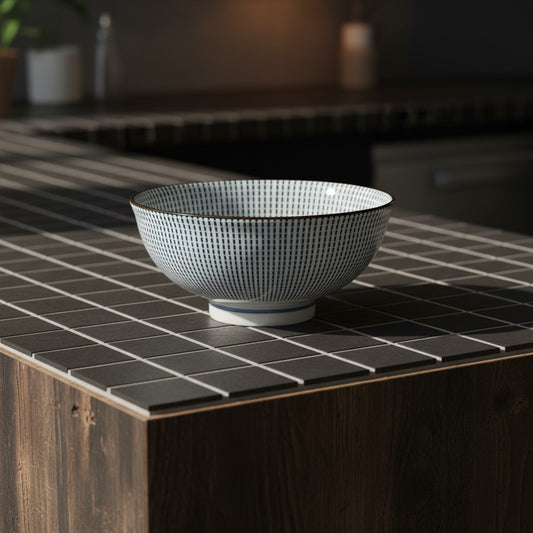 Petit bol japonais Yugen lab en céramique blanche et bleue avec motif tokusa à rayures sur un comptoir carrelé noir