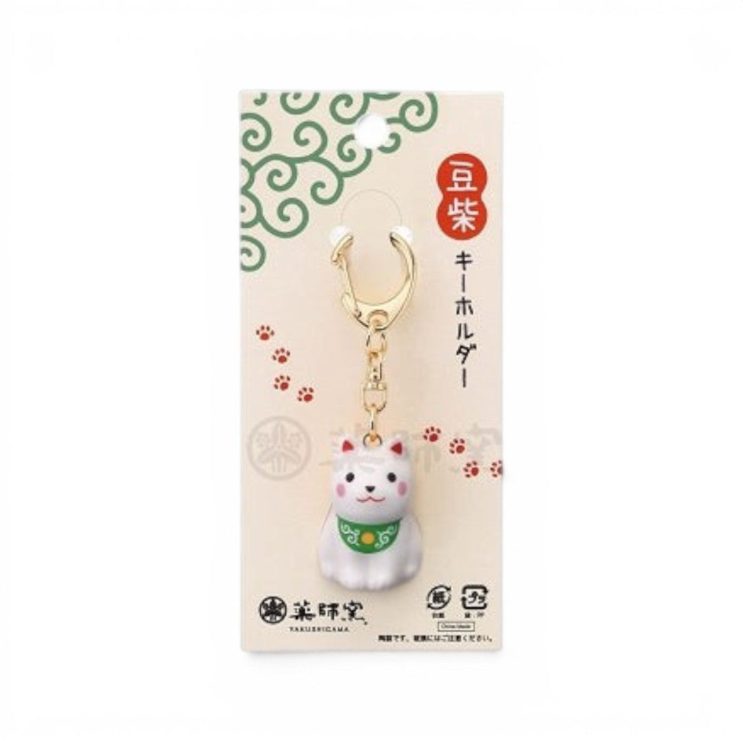 Porte-clés Yugen lab en porcelaine représentant un chien Mameshiba blanc avec un collier vert à motif traditionnel