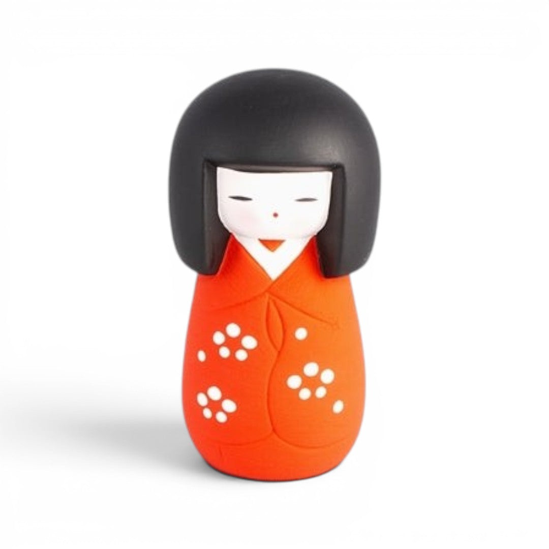 Poupée Kokeshi Yugen lab en porcelaine orange et noire avec motifs floraux blancs, symbole de protection japonaise
