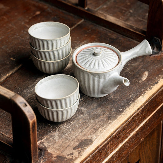Service à thé Yugen lab en céramique grise avec théière traditionnelle et tasses cannelées sur table en bois ancien