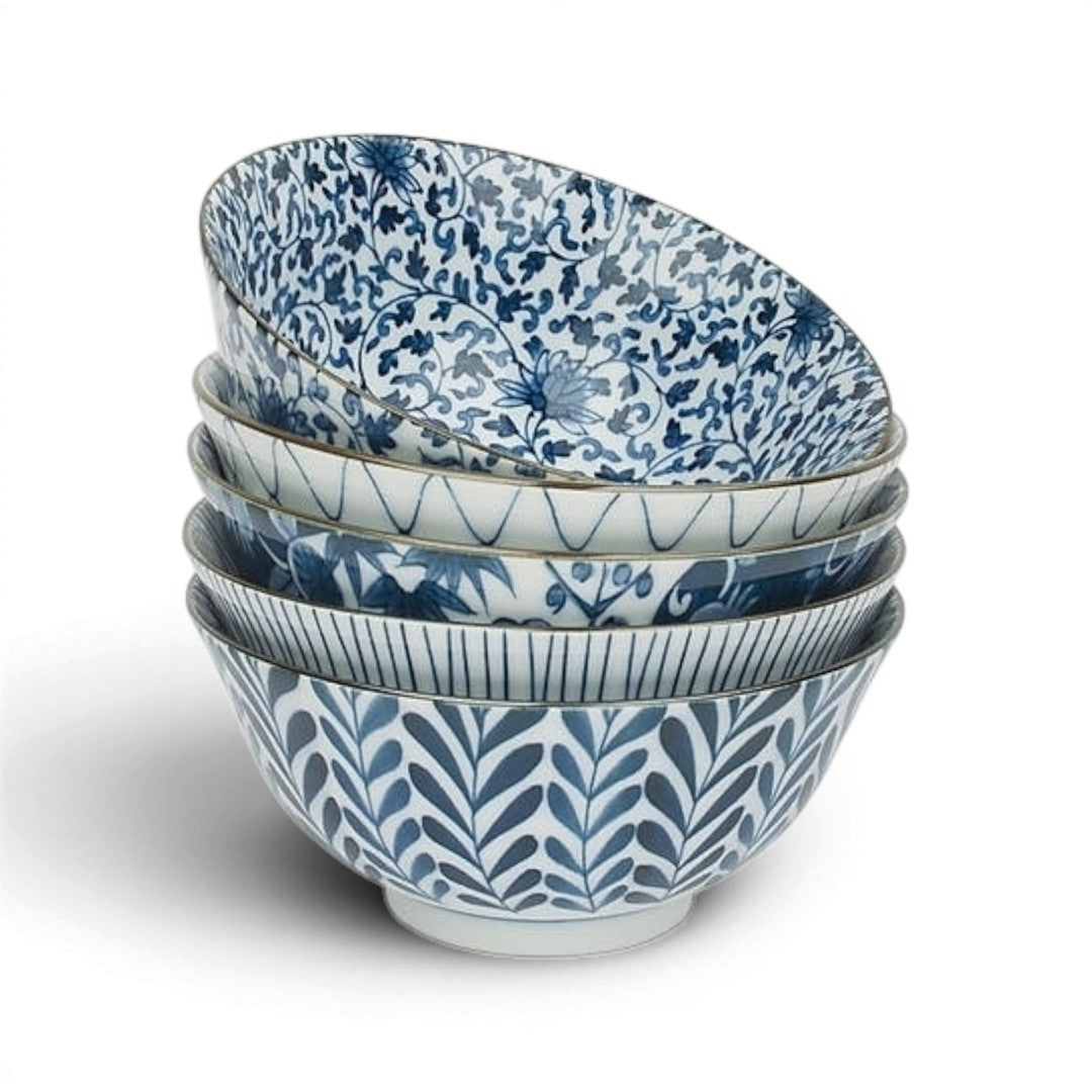Set de 5 bols japonais Yugen lab en céramique avec motifs floraux bleus et blancs, empilés sur fond blanc.