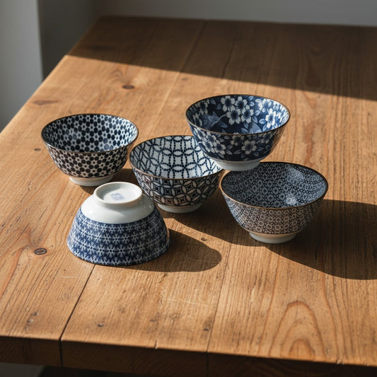 Set de 5 bols à riz Yugen lab en porcelaine blanche et bleue avec motifs graphiques japonais sur une table en bois