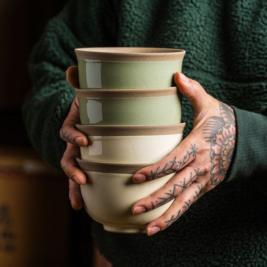 Set de 4 bols Yugen lab en céramique japonaise aux tons pastel, tenus par des mains tatouées