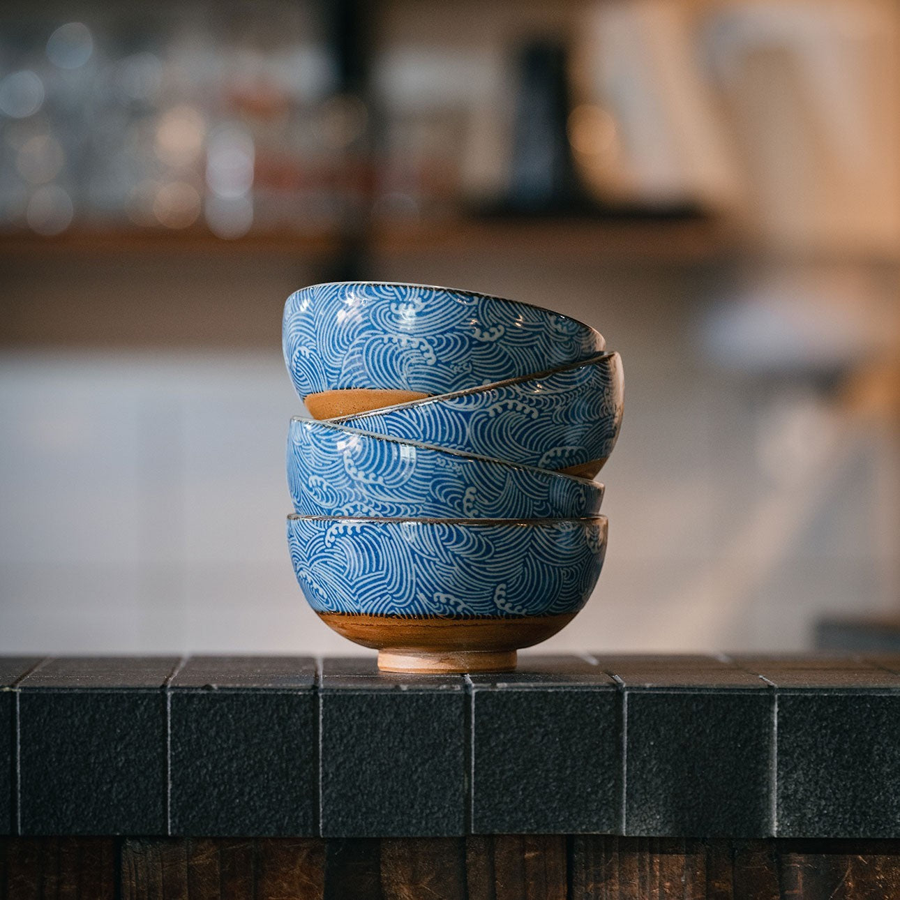 Set de quatre bols japonais Yugen lab en céramique bleue et blanche avec motif de vagues Nami empilés sur un comptoir