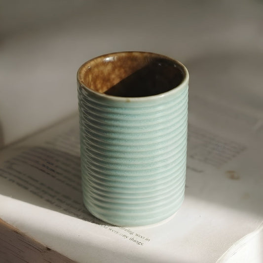 Tasse Yugen lab en porcelaine vert pastel avec relief strié et intérieur brun, style minimaliste japonais