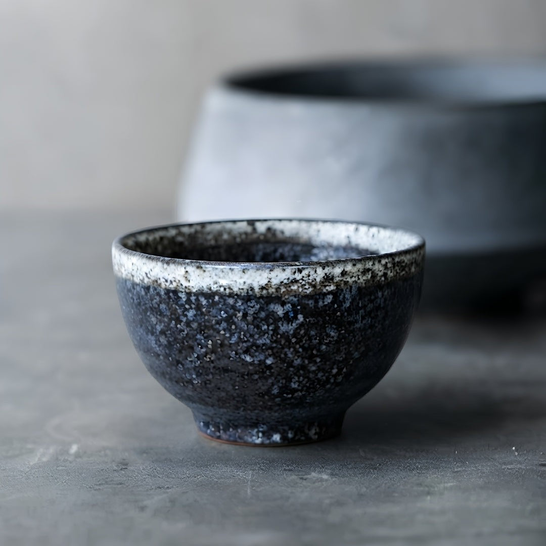 Tasse à thé Yugen lab Abura en céramique japonaise noire avec émail texturé et liseré clair, style wabi-sabi.