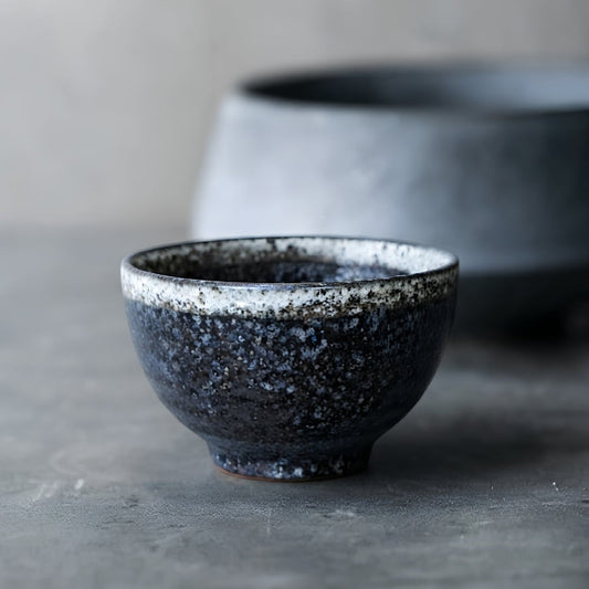Tasse à thé Yugen lab Abura en céramique japonaise noire avec émail texturé et liseré clair, style wabi-sabi.