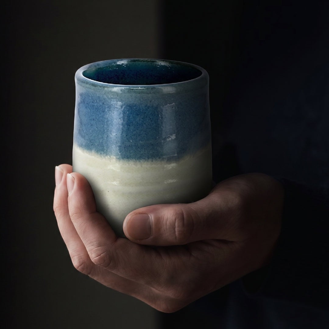 Tasse à thé Yugen lab en céramique Hagi avec dégradé bleu et blanc crème tenue entre les mains