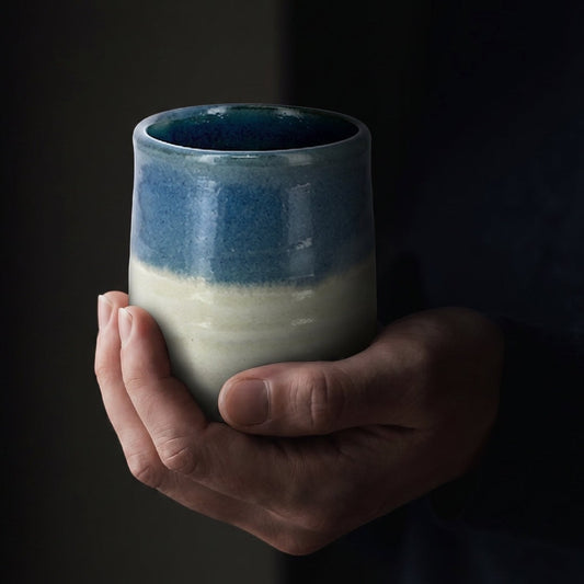Tasse à thé Yugen lab en céramique Hagi avec dégradé bleu et blanc crème tenue entre les mains