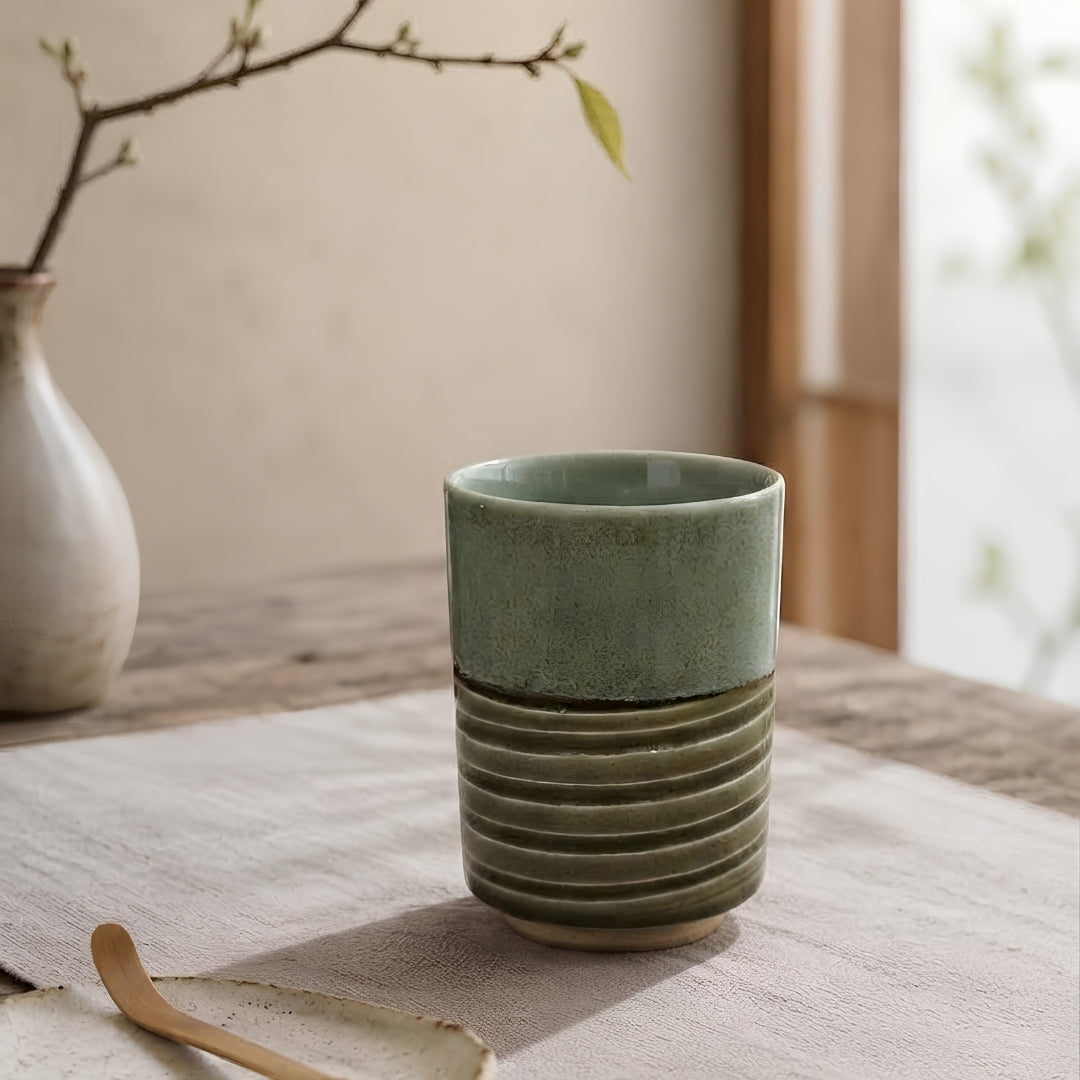 Tasse à thé japonaise Yugen lab Machiko en porcelaine avec dégradé bleu vert et base nervurée sur une table en bois