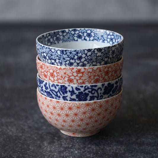 Pile de quatre tasses Yugen lab en porcelaine japonaise avec motifs traditionnels bleus et rouges sur fond blanc